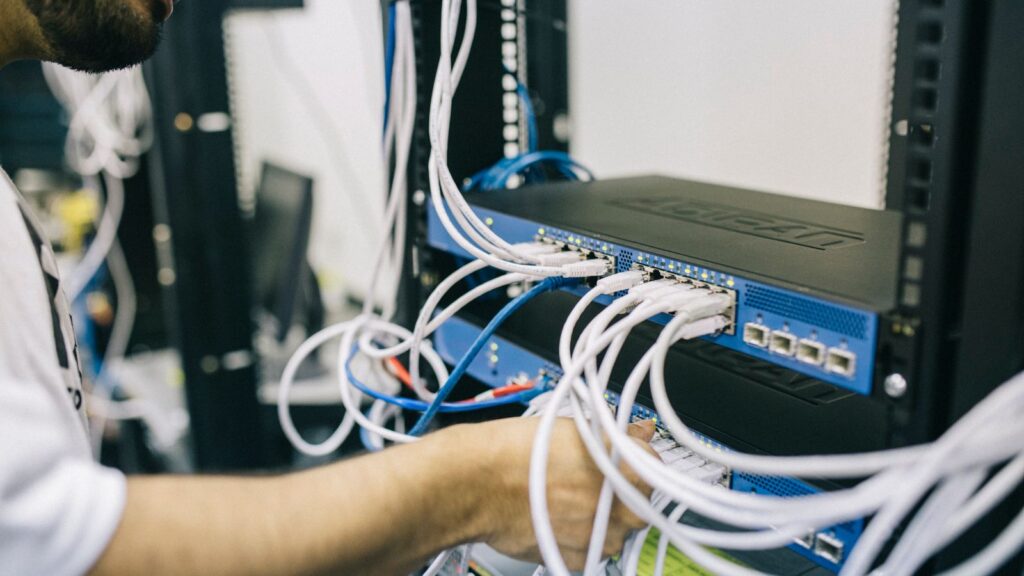 Technicus werkt aan een netwerkswitch voor het berekenen van het PoE-budget