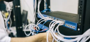 Technicus werkt aan een netwerkswitch voor het berekenen van het PoE-budget